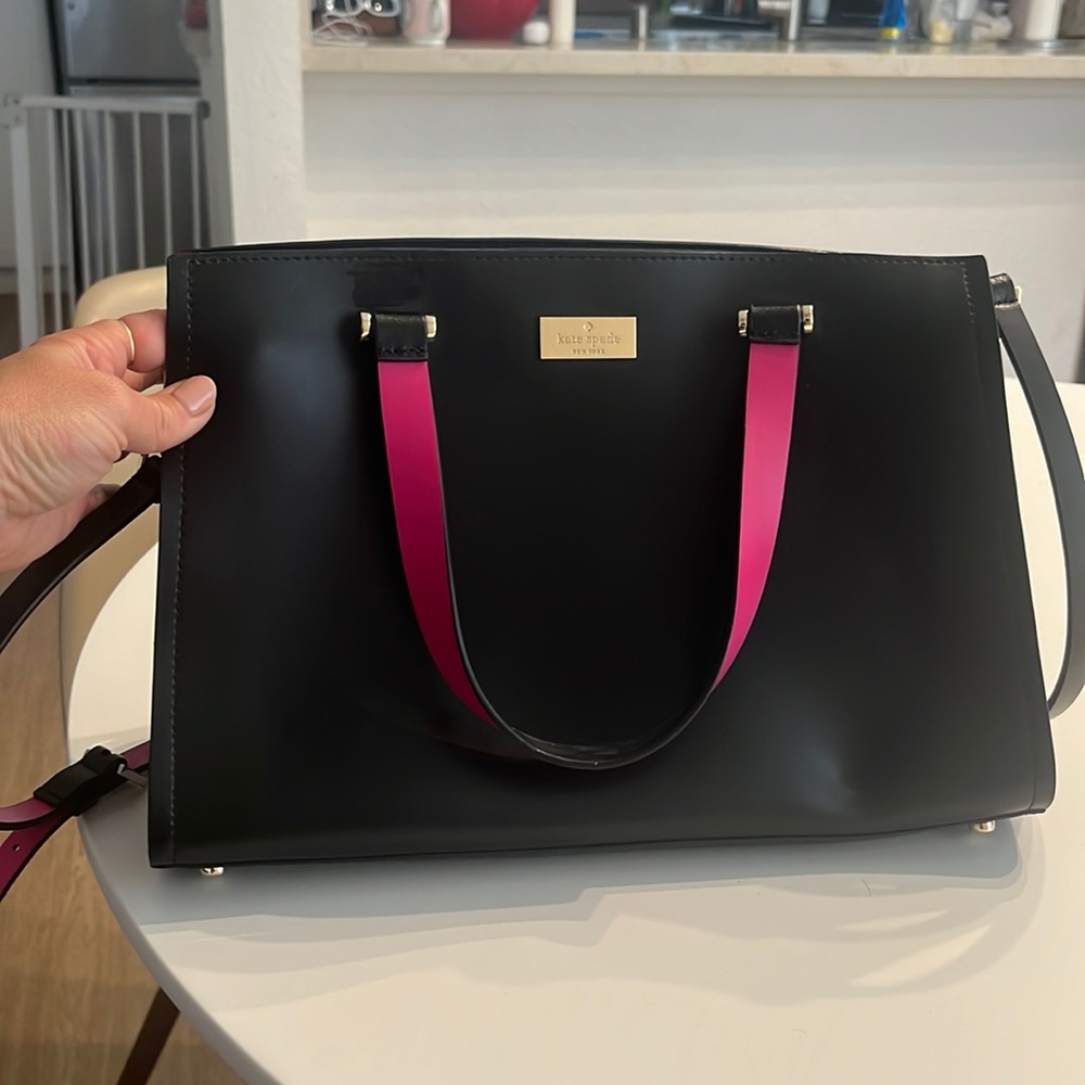 Good as new black leather mid-sized bag with vibrant pink trim and lining